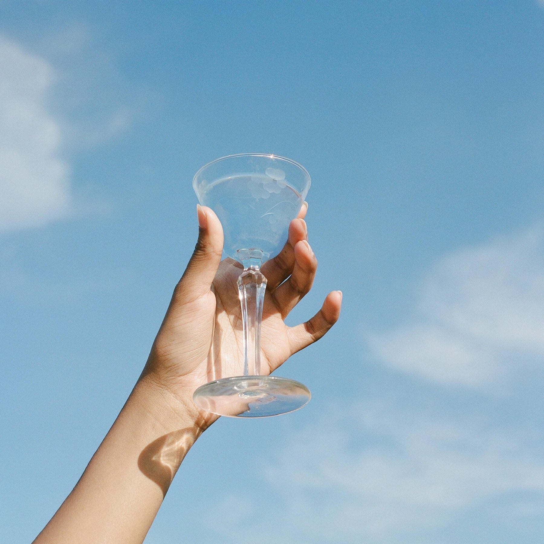 A clear glass toward a blue sky, evoking calm and clarity